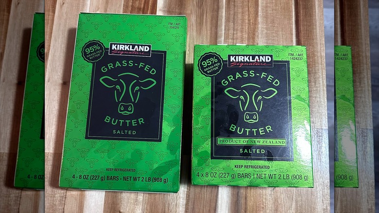The old and new Kirkland Signature Grass-Fed Butter boxes sitting side by side on a wooden table
