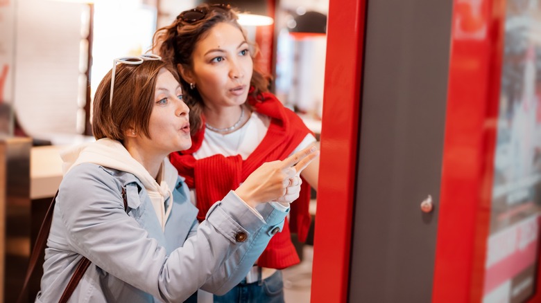 Two women look at a fast food menu