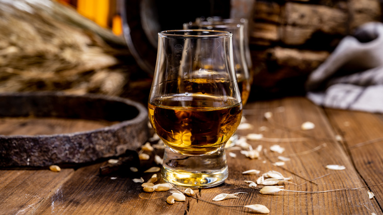 Glass of whiskey surrounded by grain