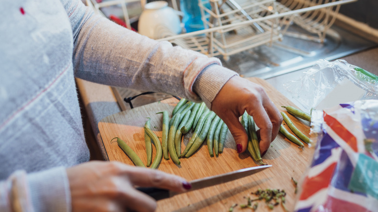 Woman chopping fresh spring beans