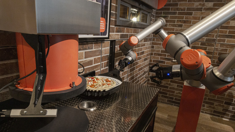 Robots making a pizza in the kitchen