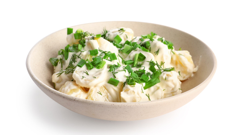 Bowl of potato salad on white background