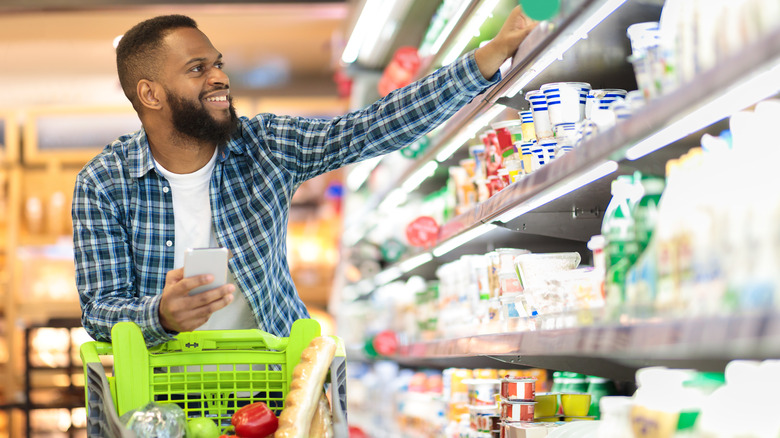 shopper picking food items in the dairy section