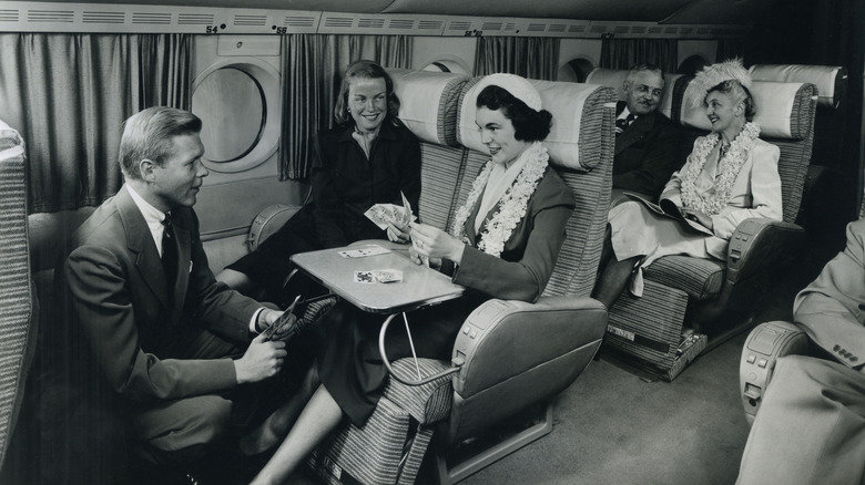 Passengers aboard a plane circa 1949 playing cards