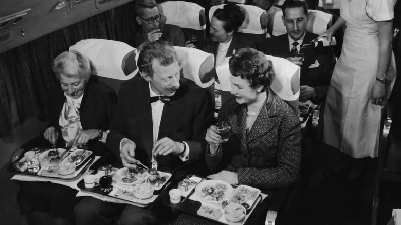 A photo from the '50s depicting passengers eating their in-flight meal