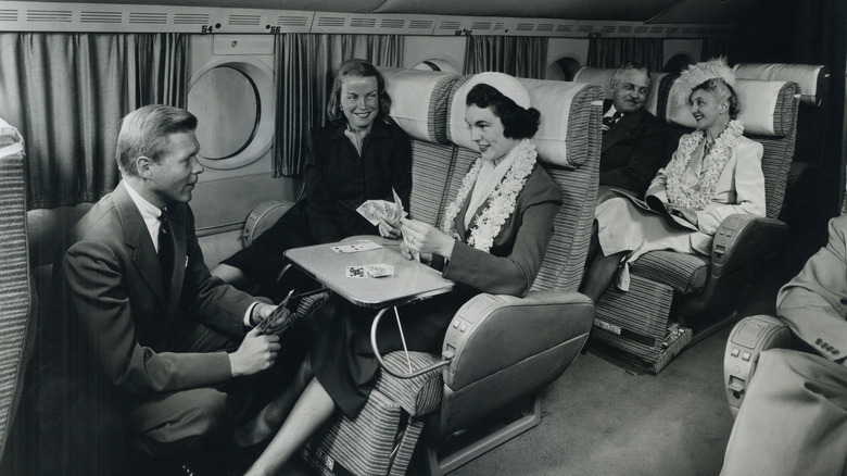 Passengers aboard a plane circa 1949 playing cards