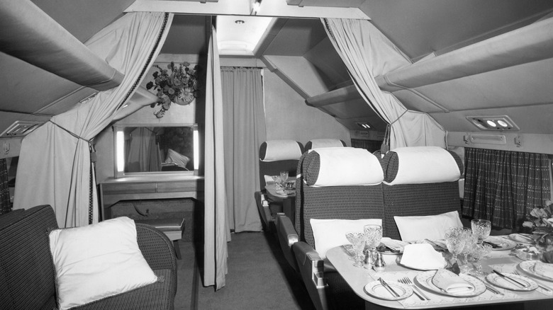 The empty cabin of a plane showing a table set with fine glassware