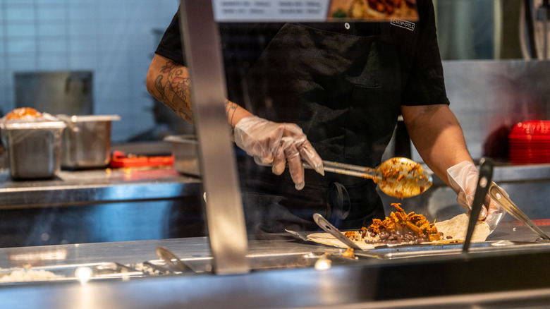 chipotle employee making burrito 