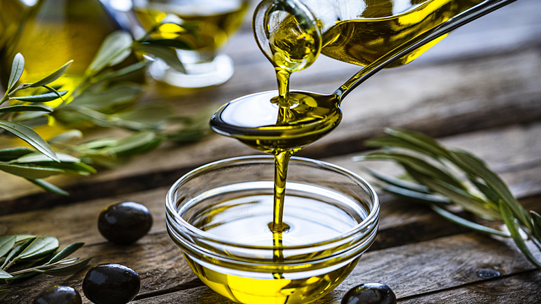Olive oil being poured into a bowl over a spoon