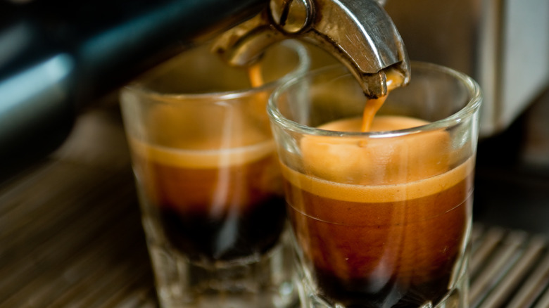 Espresso coming out of machine into glasses