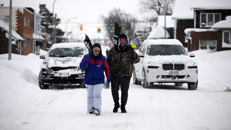 Buffalo residents walk with snow shovels
