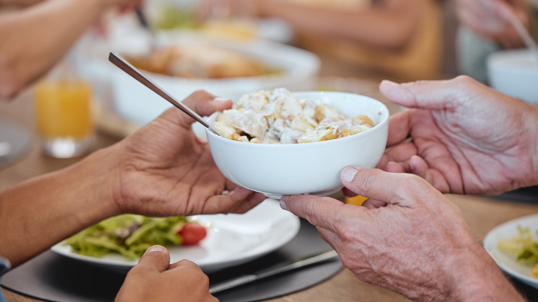 people passing bowl of potato salad
