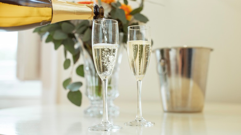 Pouring opened champagne into glasses