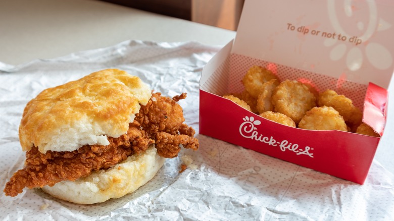 Chick-fil-a chicken biscuit and hash browns on table