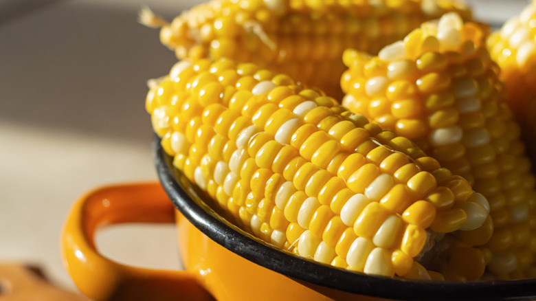 Boiled corn on the cob in brown bowl