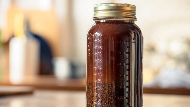 A mason jar filled with coffee grounds and water