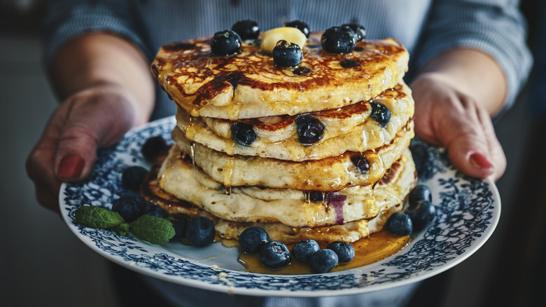 Person holding blueberry pancakes