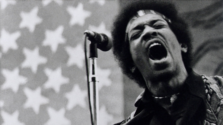 Jimi Hendrix singing behind a microphone