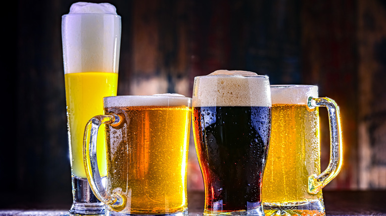 Different sized glasses of beer on a counter