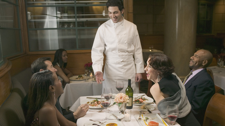 A chef talks to diners