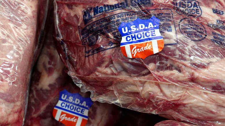 A close-up of packaged raw meat with a "USDA Choice" sticker