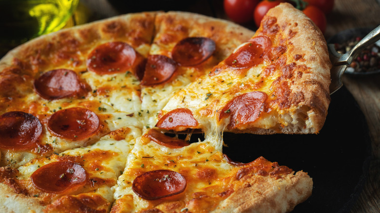 A slice is pulled from a pepperoni pizza
