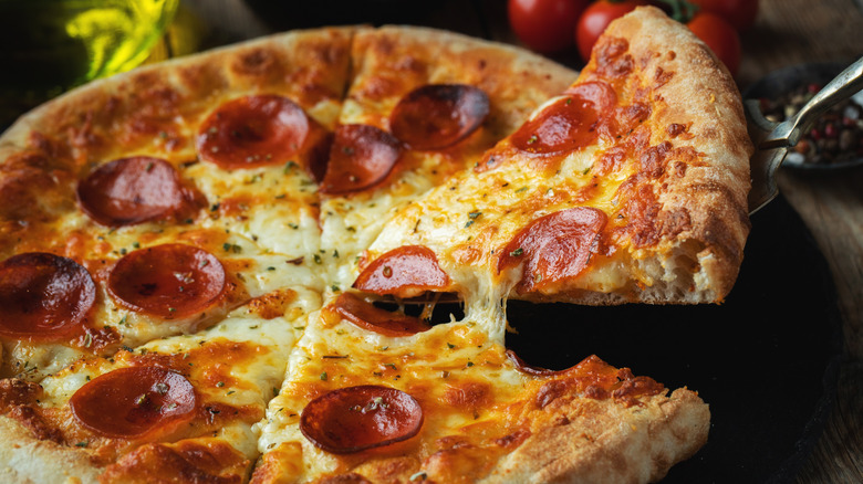 A slice is pulled from a pepperoni pizza