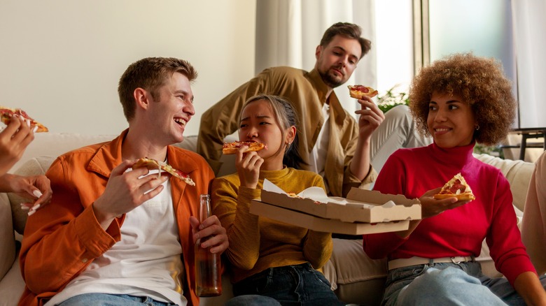 A group of young people enjoy a pizza together
