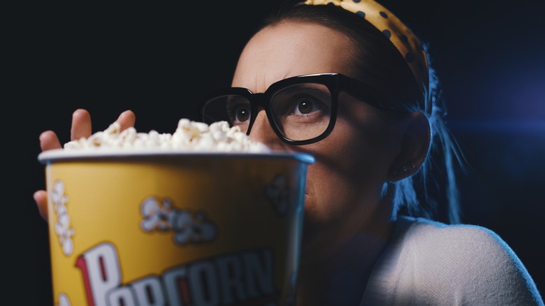 woman holding popcorn at movie theater