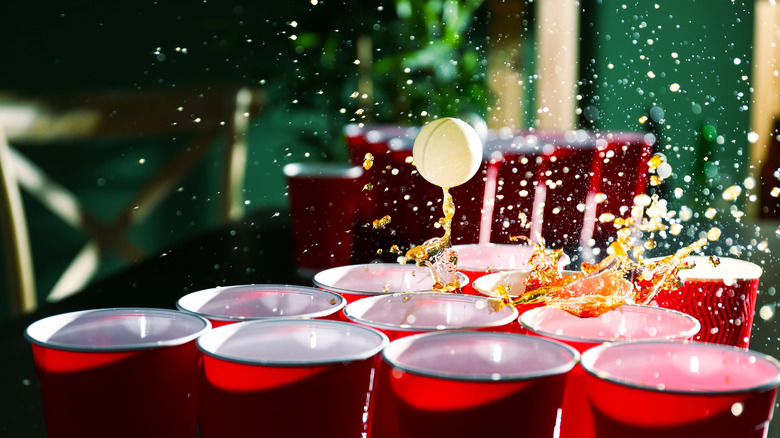 pong ball with beer splashing in cups