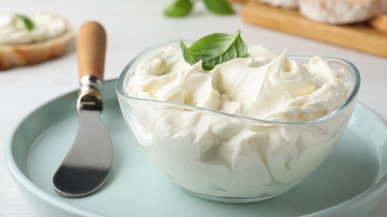 Glass dish of cream cheese with basil