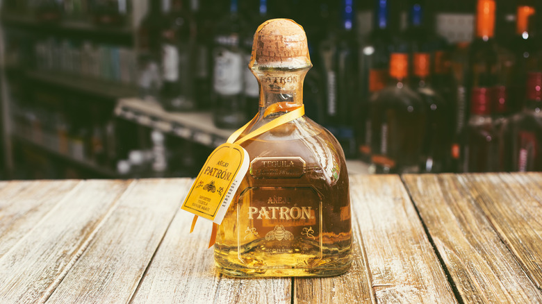 bottle of premium Patron anejo tequila on wood counter