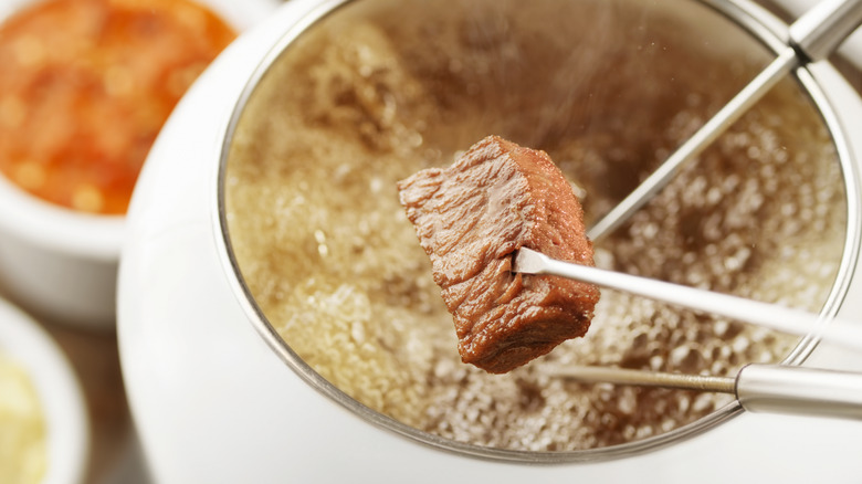 Dipping steak in oil fondue