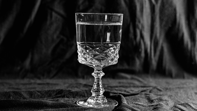 A glass of clear vodka against a dark background