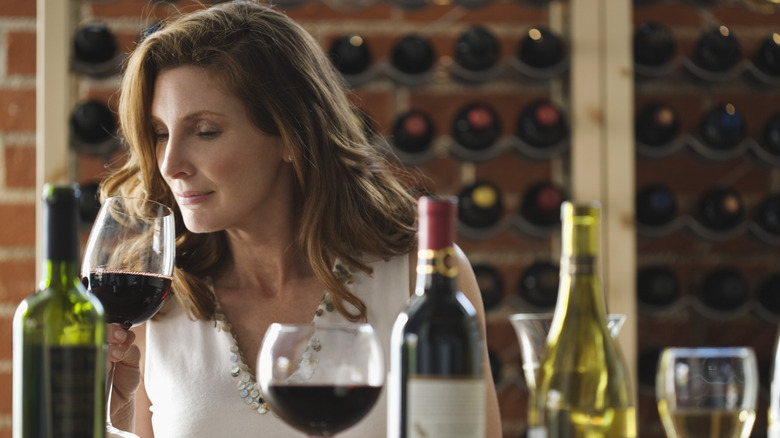 Person sniffing a glass of red wine