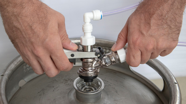 Hands replacing swivel head on beer keg