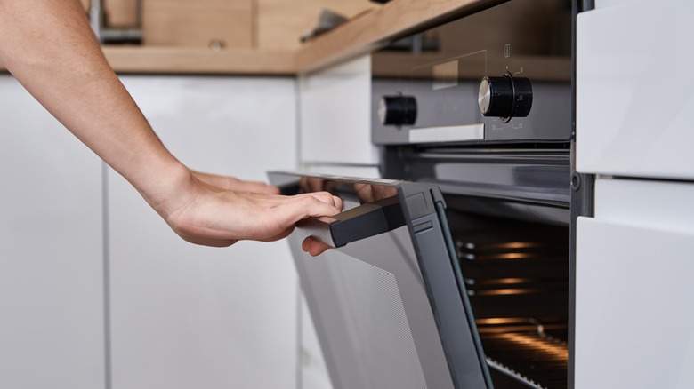 person opening oven door