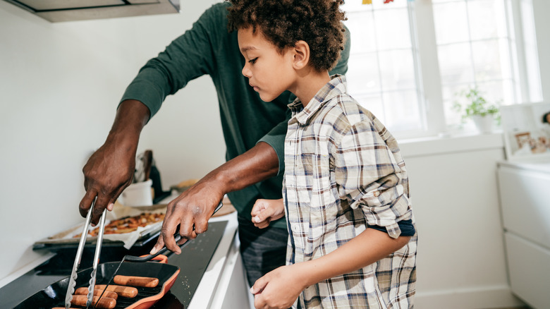 family pan-frying hot dogs
