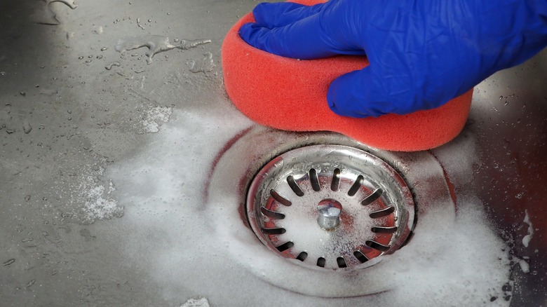 Person scrubbing sink drain