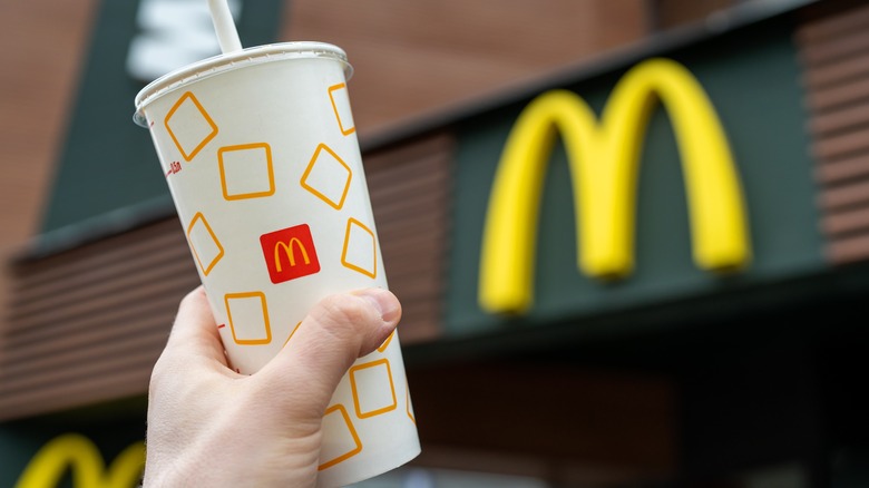 A hand holding a McDonald's cup