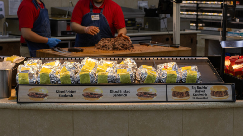 Buc-ee's workers chopping brisket behind sandwich display