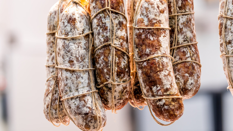 Hanging dry-cured meats with mold
