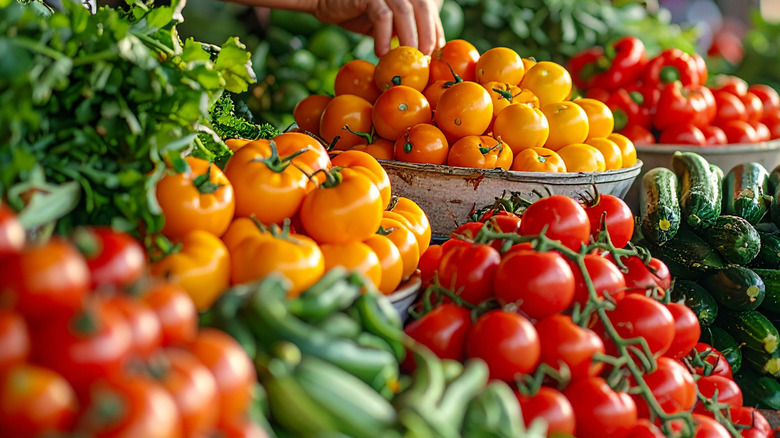 A market stall with various piles of tomatoes