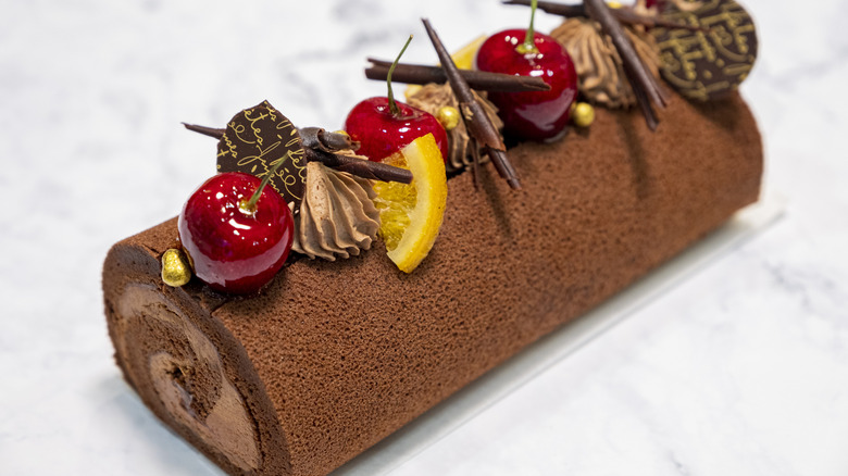 A Yule log cake with decorations is displayed.