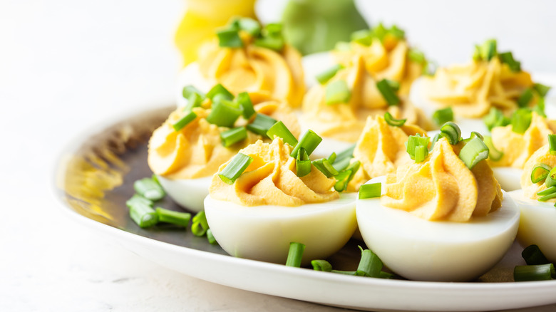 deviled eggs with chives on a plate