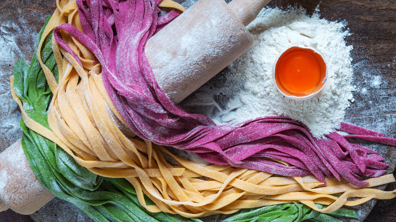 colored pasta draped on rolling pin