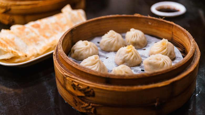 Steamed buns on parchment paper in bamboo basket