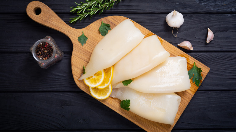 Raw squid pieces on cutting board