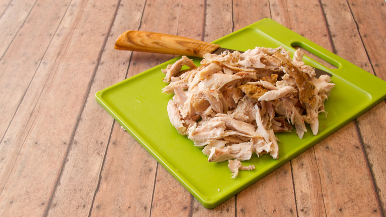 Shredded rotisserie chicken on cutting board