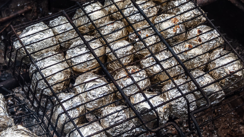 foil-wrapped potatoes over hot coals